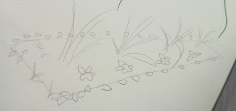 A sketch of a flower bed with petals lining it and bit of grass sticking up in the middle