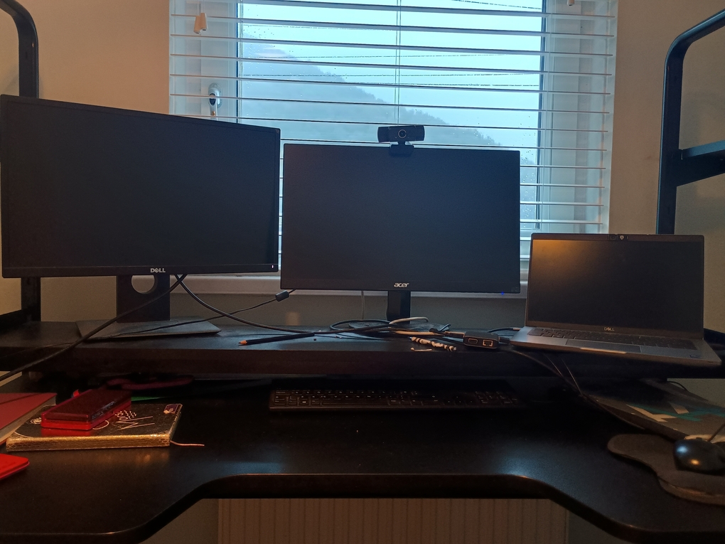 Photo of two monitors and laptop on black desk